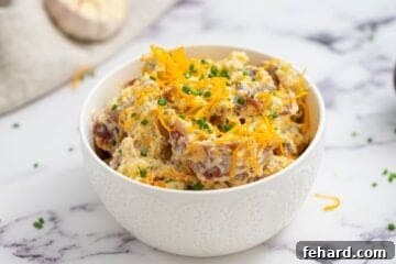 Bacon Ranch Potato Salad topped with cheese, chives, and bacon.