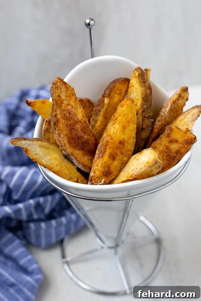 Crispy Jojo potatoes served in a white fry holder, showcasing their golden-brown exterior and delicious seasoning.