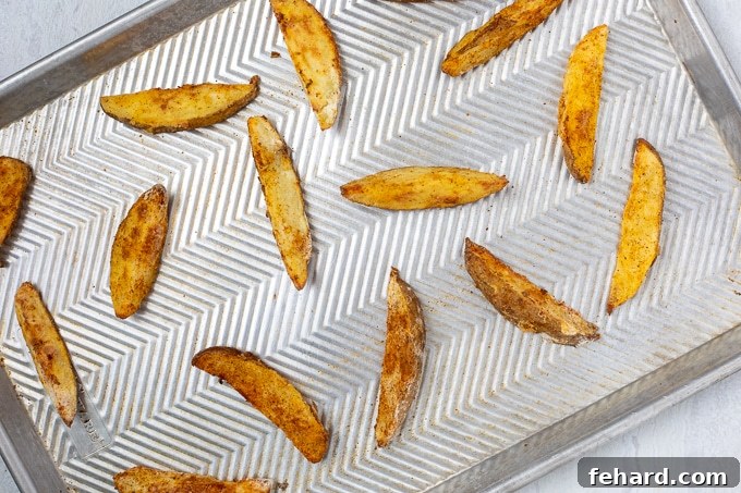 Freshly baked Jojo potato wedges, golden and crispy, on a baking sheet, ready to be served.