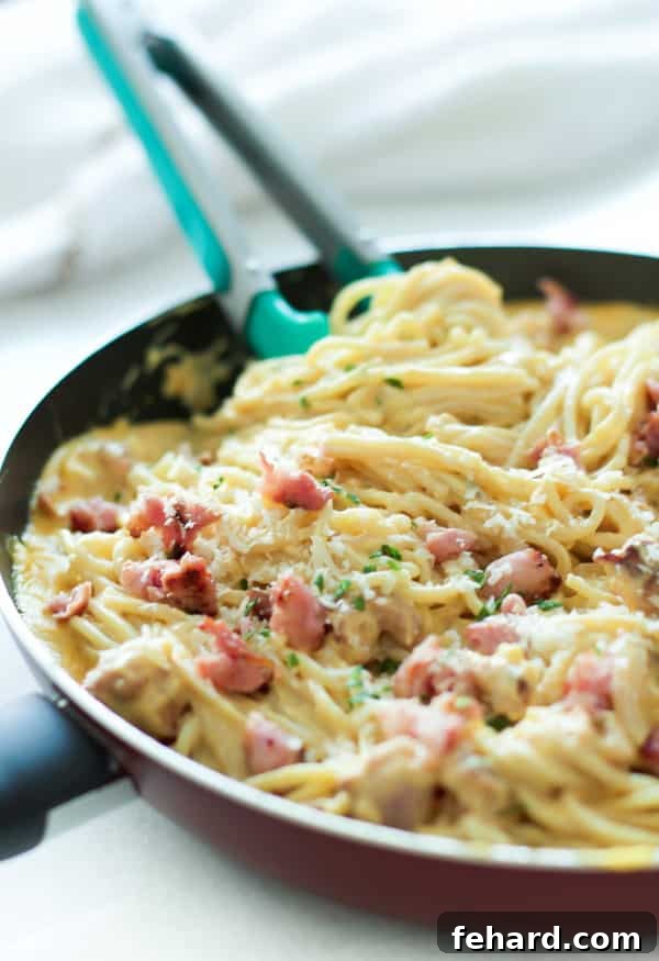Creamy Pumpkin Alfredo Sauce with Italian Sausage, served in a skillet.