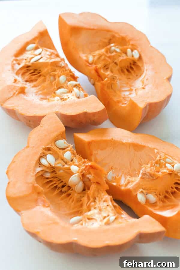 Pumpkin wedges with seeds removed and pierced with a fork, ready for roasting.