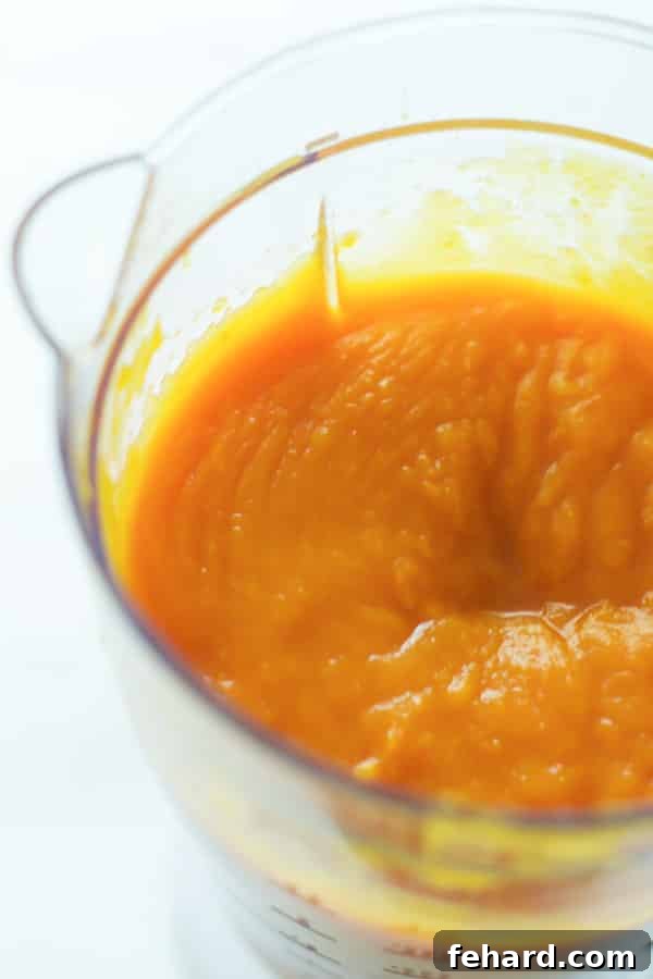 Smooth homemade pumpkin puree in a blender, showing the final step of preparation.