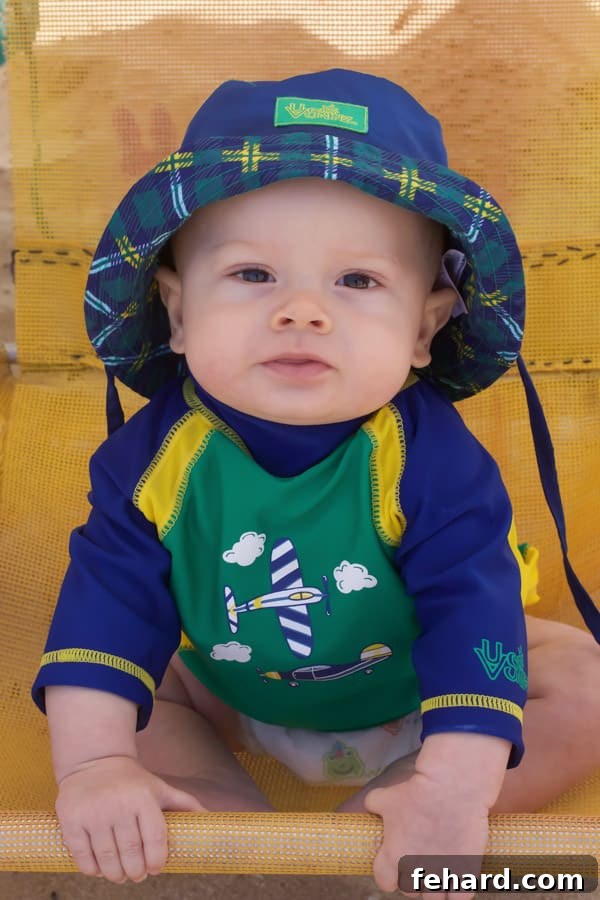 Baby Thomas joyfully playing on the soft sands of Praia do Forte, with the clear blue ocean in the background.