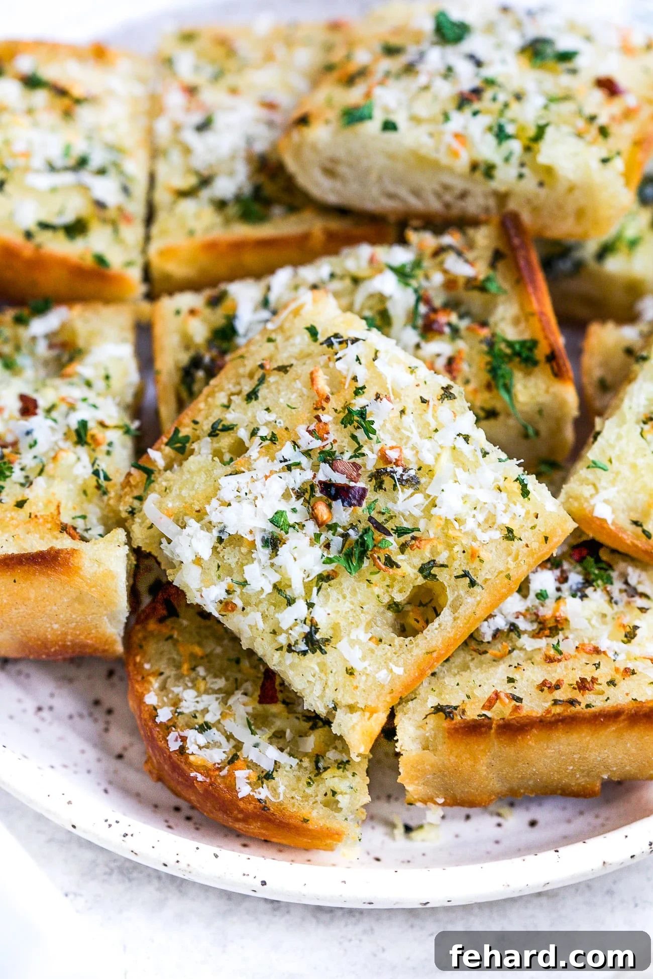 Pieces of garlic bread on a white serving plate.