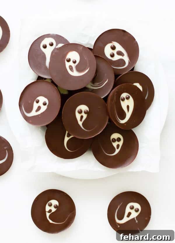 Simple & Quick 2-Ingredient Ghost Chocolate Cups for Kids Adorable 2-Ingredient Ghost Chocolate Cups arranged on a wooden board, showcasing a fun and easy Halloween dessert