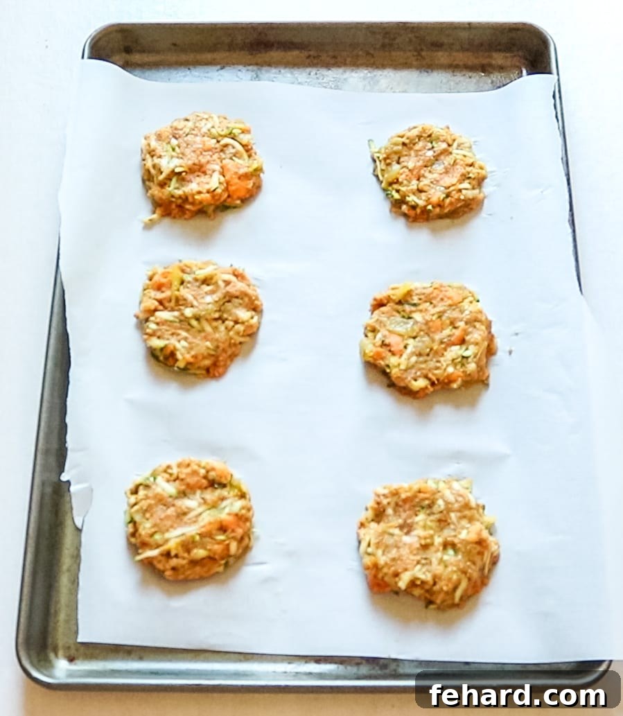 Vegan Veggie Burgers neatly arranged on parchment paper, ready to be frozen and then baked.
