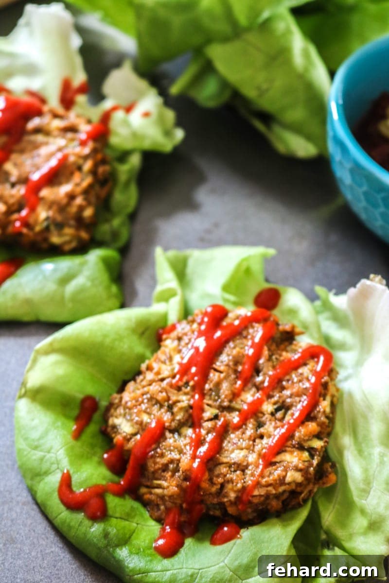 A delicious gluten-free sweet potato burger artfully presented on a fresh lettuce wrap, ready to be enjoyed.