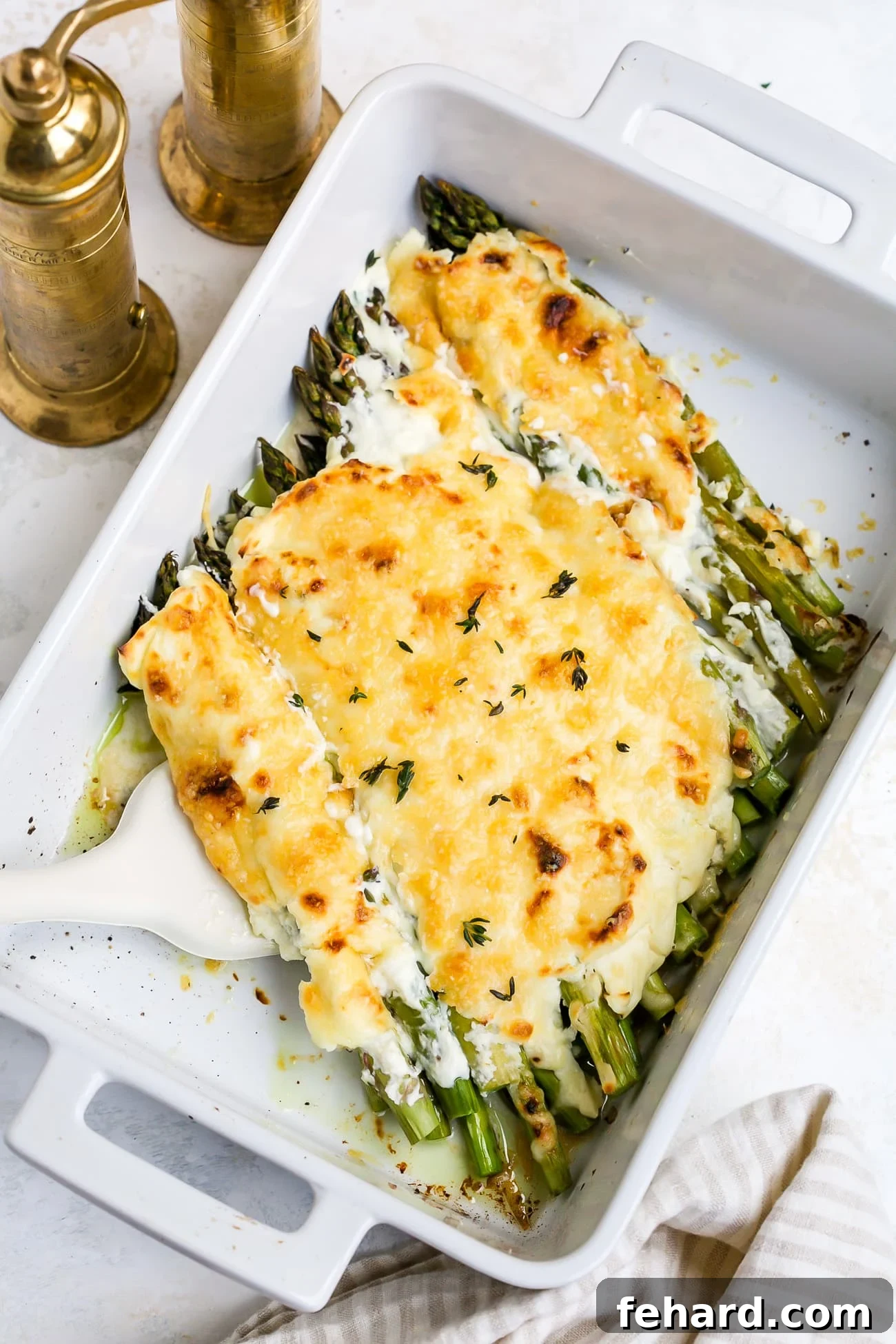 Golden Asparagus Gratin 2 Asparagus casserole in a white baking dish, fresh out of the oven, golden and bubbly.