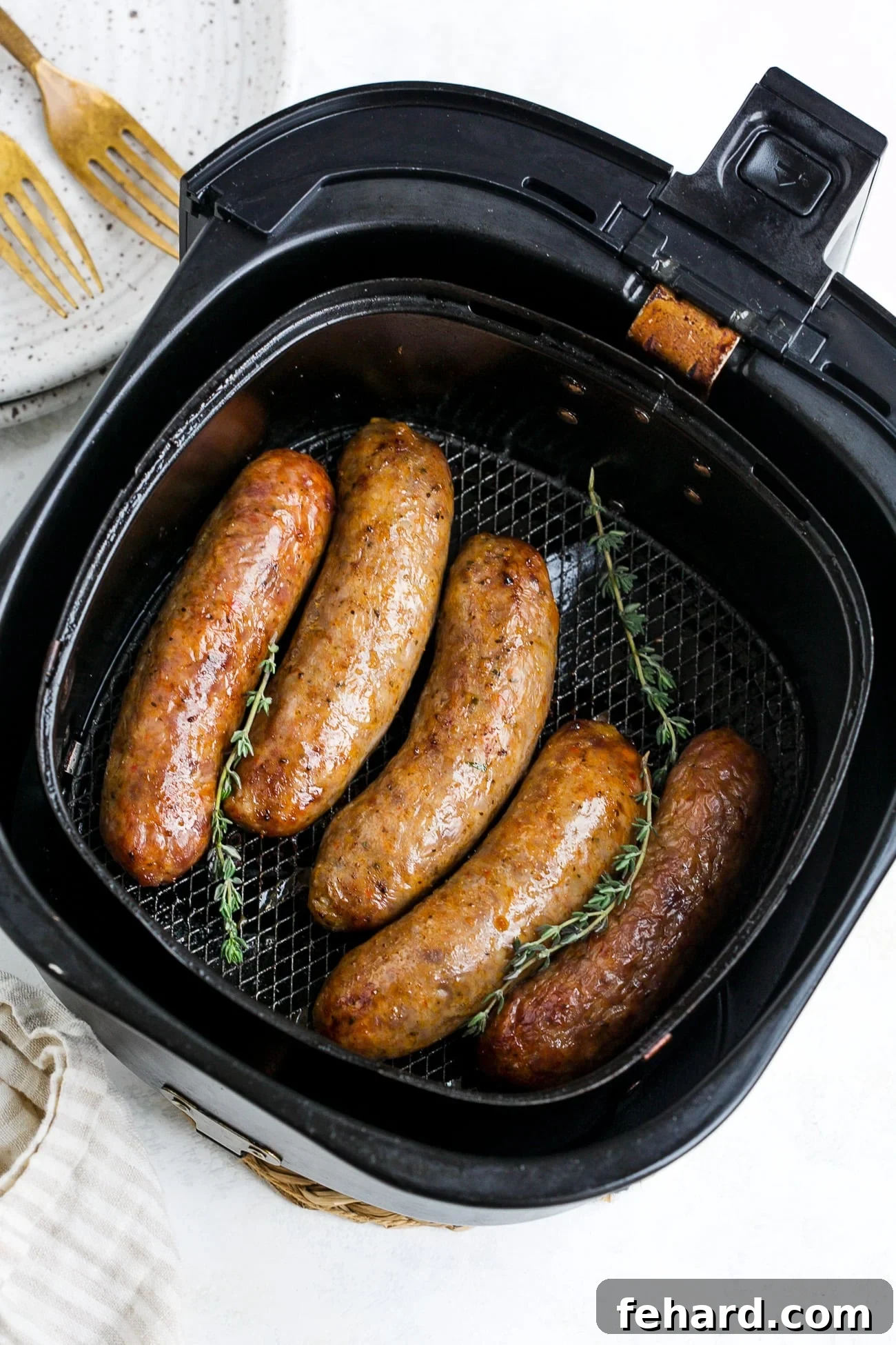 Cooked sausage in air fryer basket. 