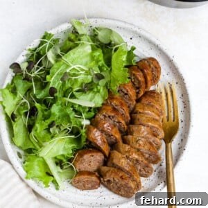 Sliced and plated air fryer sausage with a side salad.