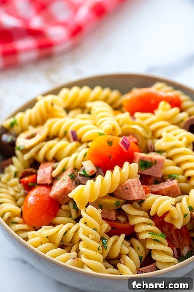 Antipasto Pasta Salad Close up of Antipasto Pasta Salad with tomatoes, onions, and pepperoni.