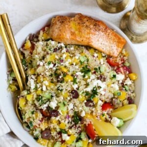 Mediterranean quinoa salad with salmon in a serving bowl.