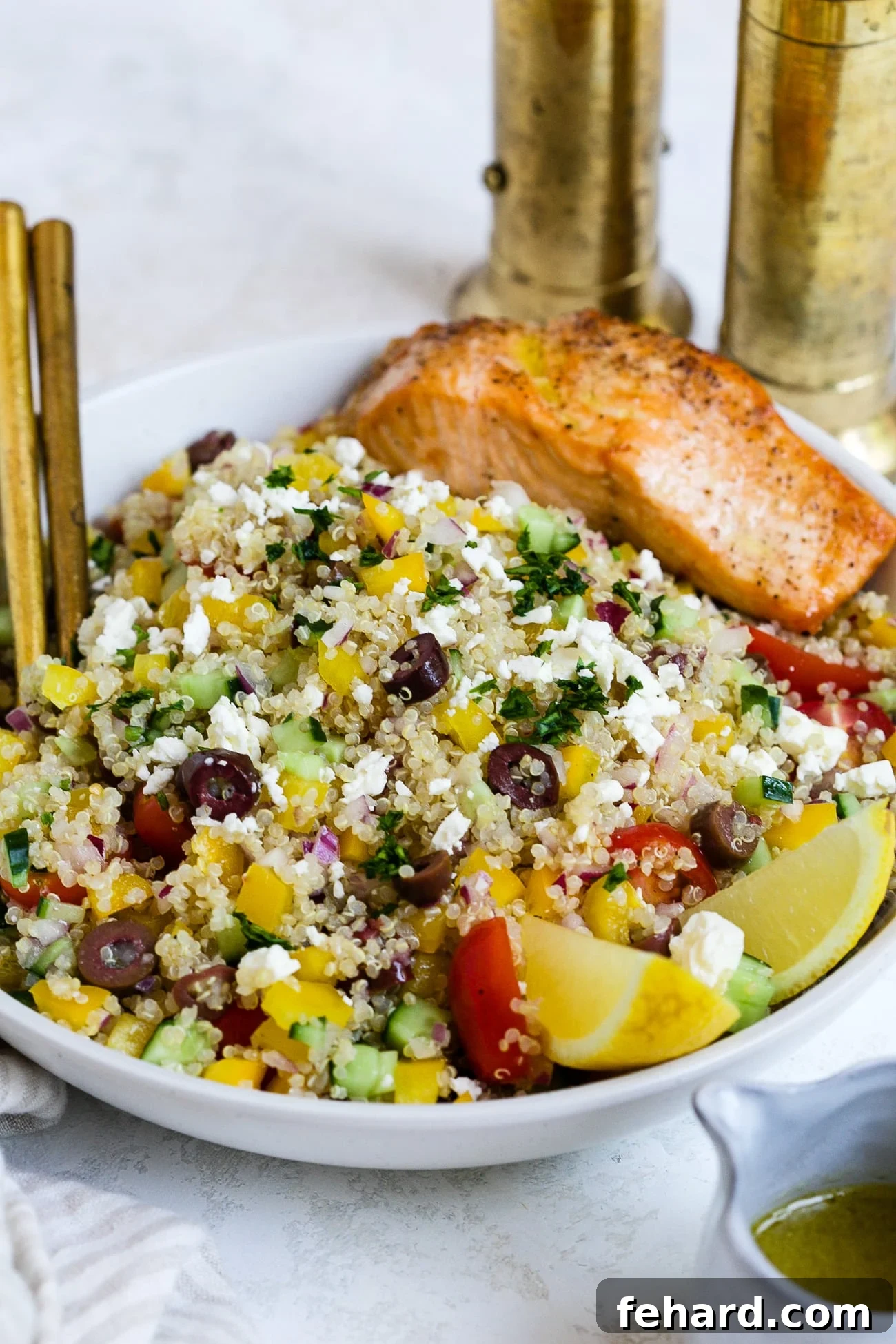 A stunning close-up of the Mediterranean quinoa salad with perfectly cooked salmon, presented in a stylish serving bowl, ready to be served.