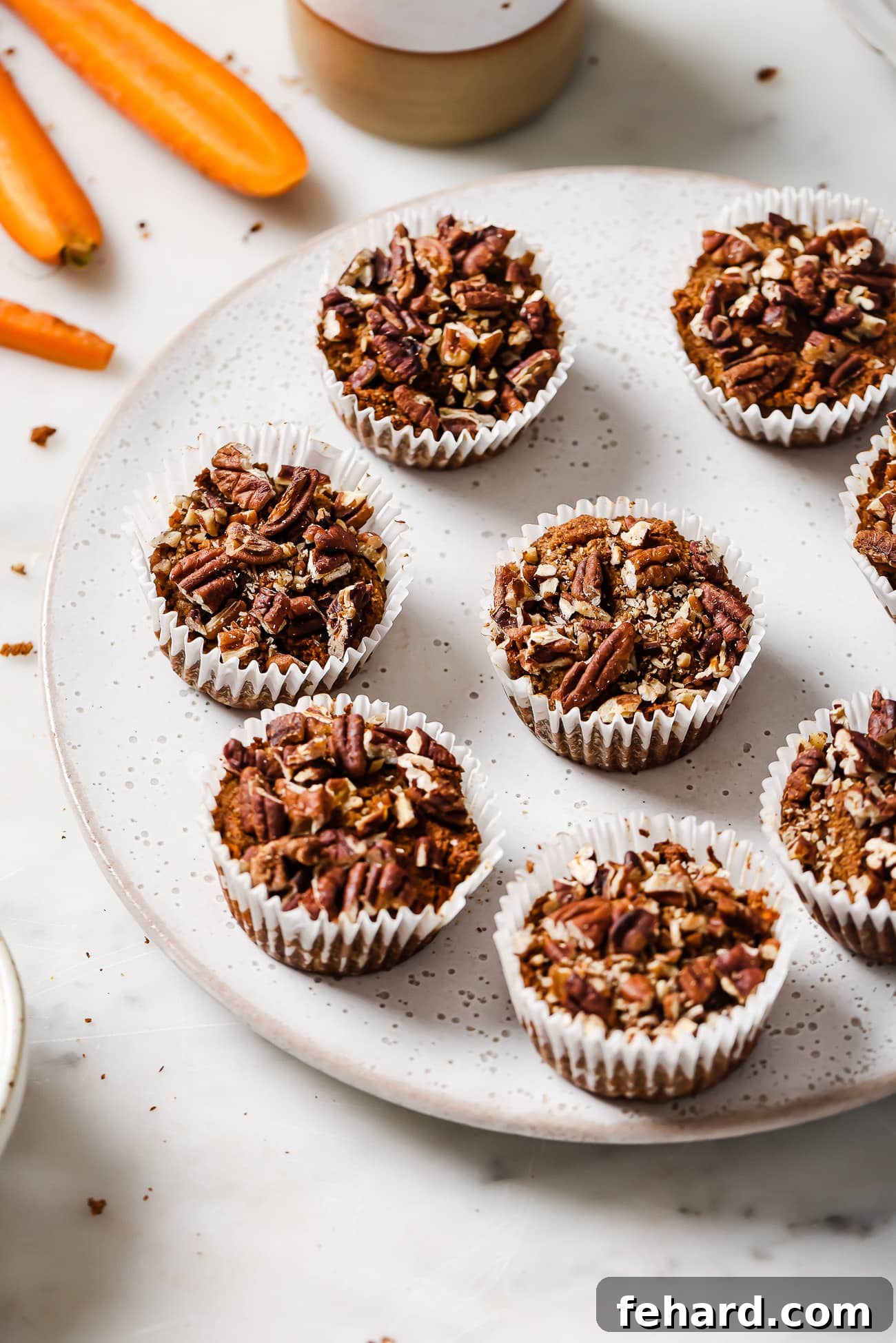 Wholesome Gluten-Free Carrot Muffins 2 Freshly baked gluten-free carrot muffins arranged beautifully on a white serving dish.