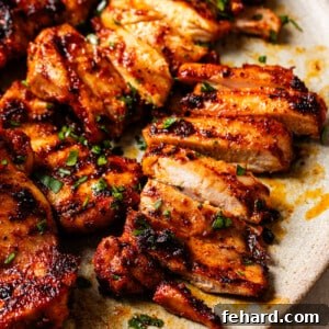 Closeup view of grilled chicken thighs, golden and smoky