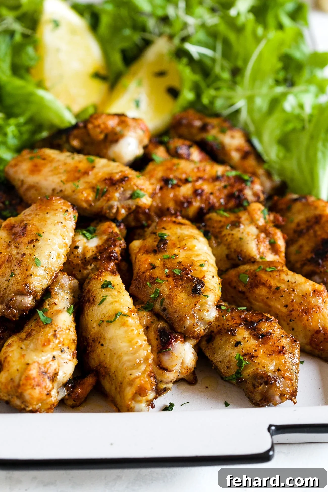 Grilled chicken wings on a white plate, ready to be served
