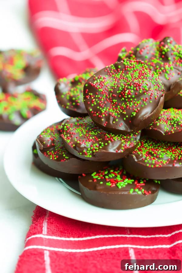 No-Bake 3-Ingredient Almond Chocolate Cups A tray of freshly made Christmas Almond Chocolate Cups, glistening with melted chocolate and festive sprinkles.