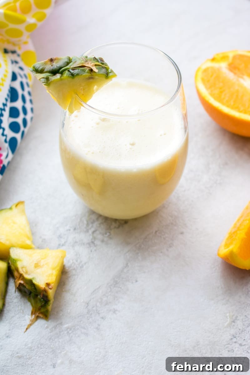 Beautifully garnished Pina Colada Smoothie with fresh pineapple wedge on the rim of the glass, evoking tropical vibes.