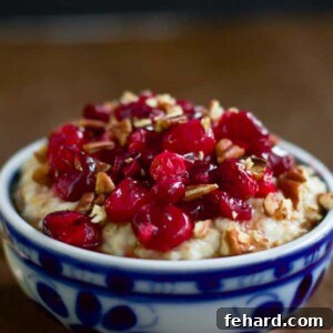 Maple Roasted Cranberry Oatmeal with a spoon, showing creamy oats and berries.