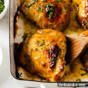 Close up of baked chicken thighs in a casserole dish.