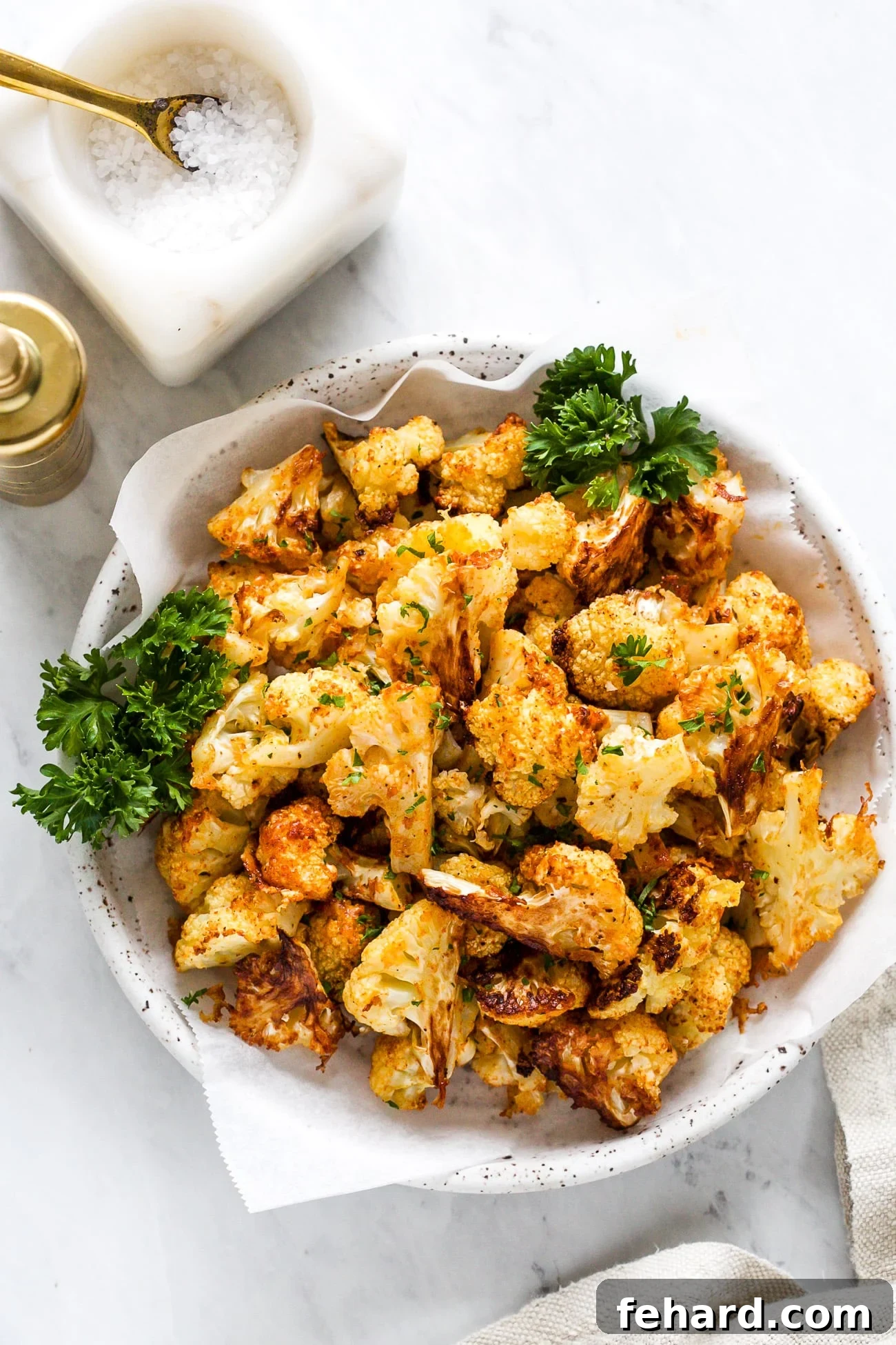 Crispy Cauliflower Poppers 2 Golden brown roasted cauliflower bites arranged on a serving plate, viewed from above, garnished with fresh parsley.