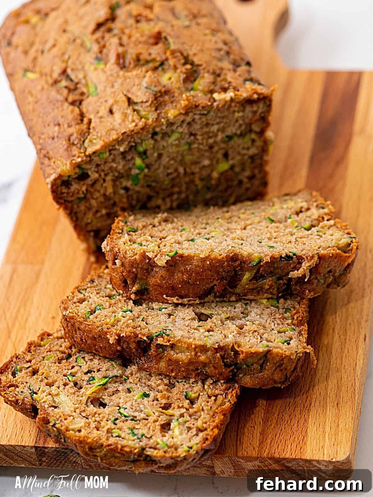 Beautifully sliced pineapple zucchini bread arranged on a rustic wooden cutting board, highlighting its moist interior with flecks of zucchini and pineapple.