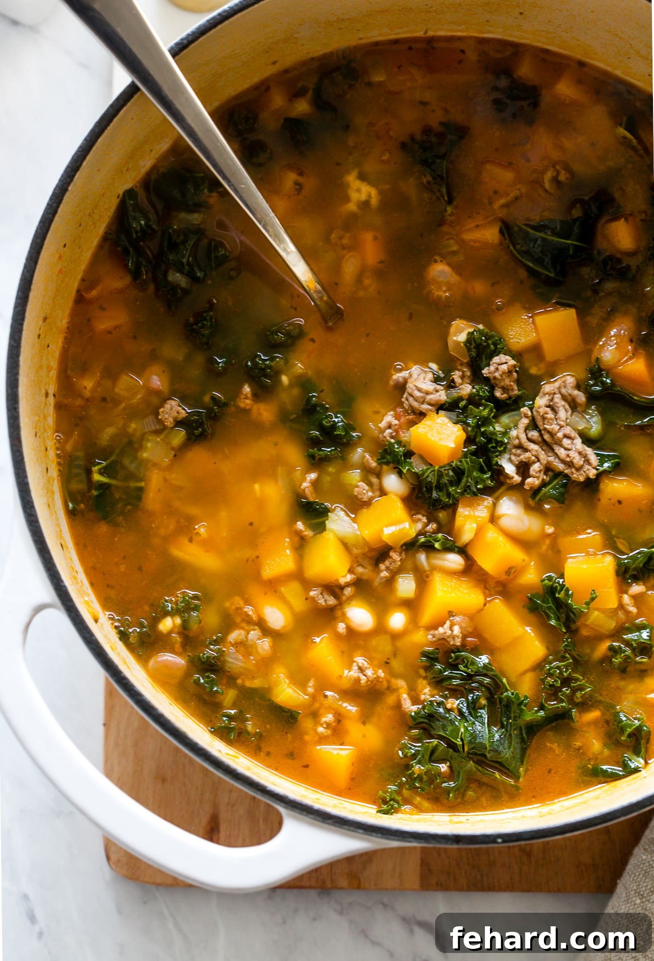 Wholesome White Bean and Kale Pot 6 A large pot filled with vibrant kale and white bean soup, steaming hot and ready to be served.