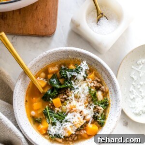 Wholesome White Bean and Kale Pot 7 White bean and kale soup in a serving bowl with shredded parmesan cheese topping.