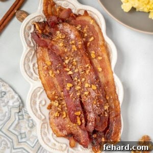 Candied Bacon on white serving platter next to scrambled eggs.