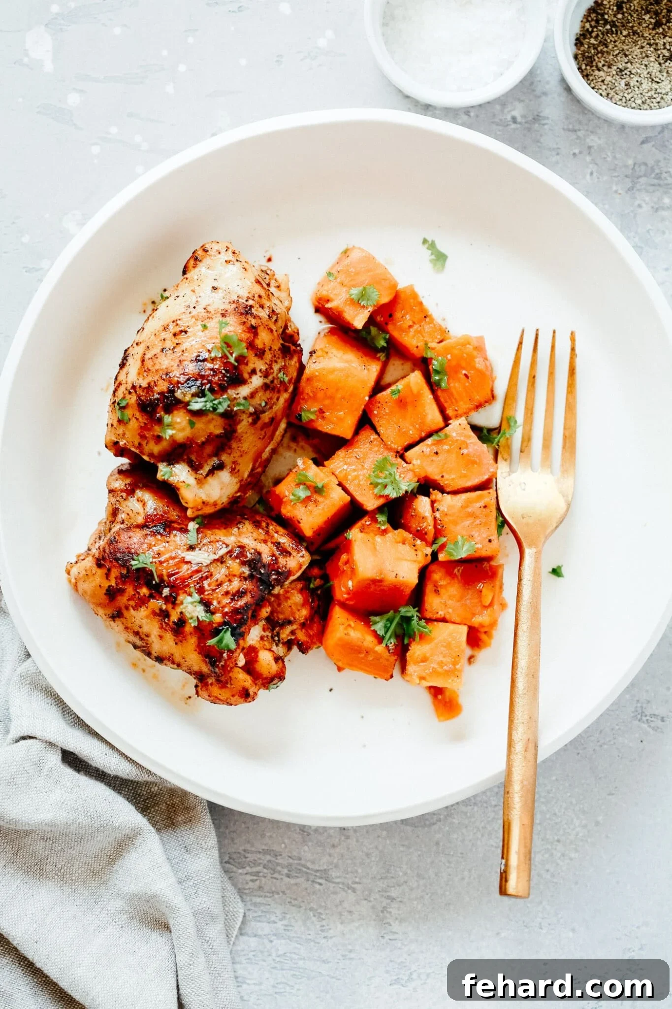 Overhead view of sweet potato and chicken thighs served in a bowl