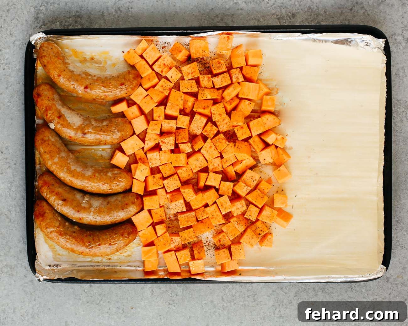 Roasting sausage and potatoes on a sheet pan with 1/3 of the pan empty.
