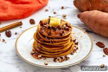 Stack of pancakes on plate topped with maple syrup and chopped nuts.