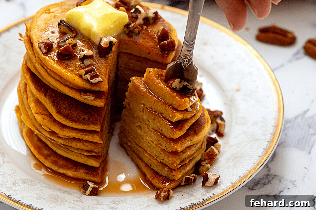 Close-up shot of a sliced sweet potato pancake with a bite taken out, showing its fluffy interior.