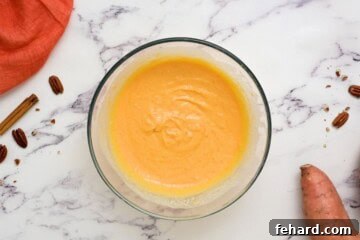 Wet ingredients being whisked in a bowl for sweet potato pancakes.