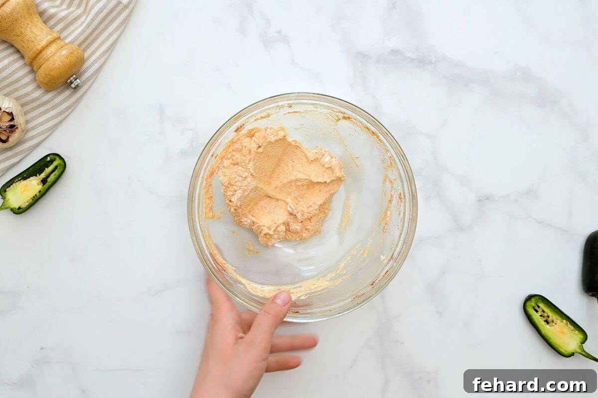 Low Carb Jalapeno Poppers Mixing bowl with cream cheese mixed together with spices for filling for poppers.