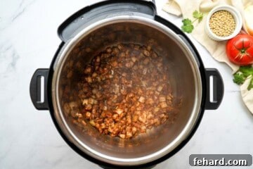 Onions and spices toasted in inner pot inside Instant Pot.