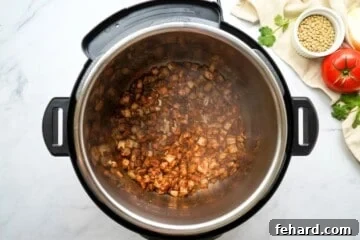 Onions and spices toasted in inner pot inside Instant Pot.