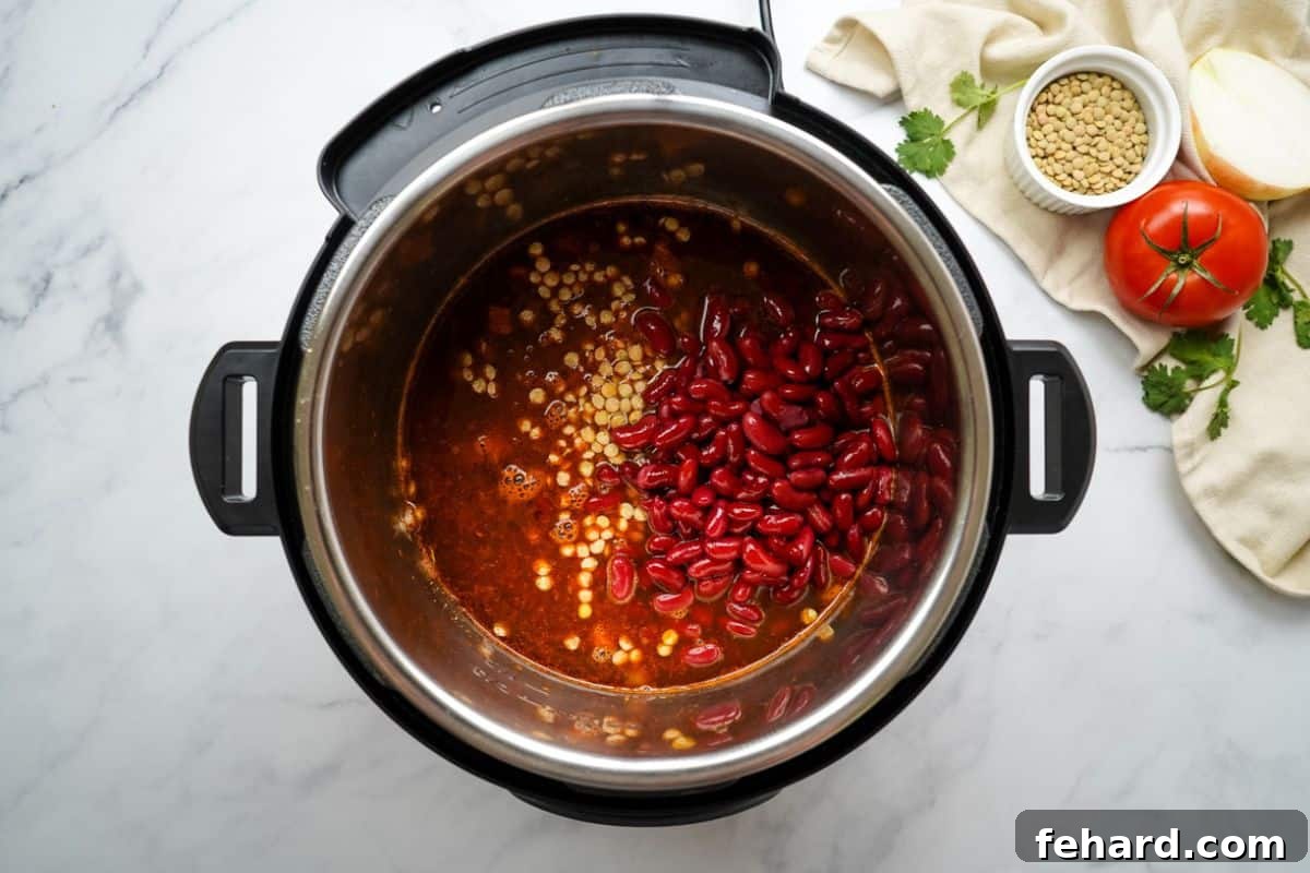 Layered ingredients for Vegan Lentil Chili inside the Instant Pot before adding tomatoes.