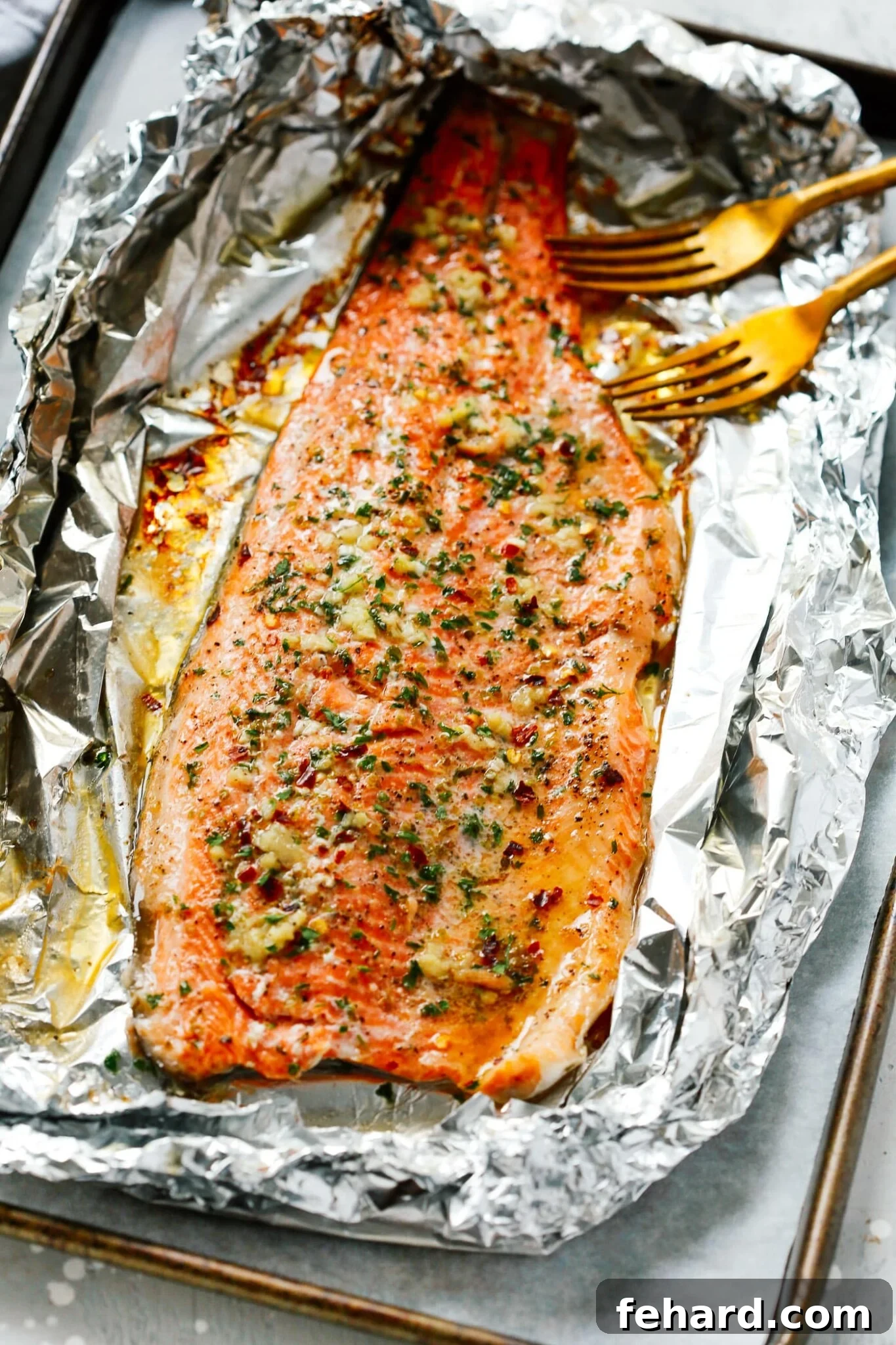 Mouthwatering Garlic Butter Rainbow Trout 6 Overhead view of a cooked Rainbow Trout fillet on a baking sheet, garnished and ready for serving.
