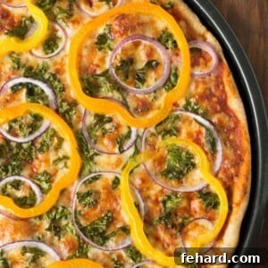 A close-up of a homemade Kale, Peppers and Red Onion Pizza slice