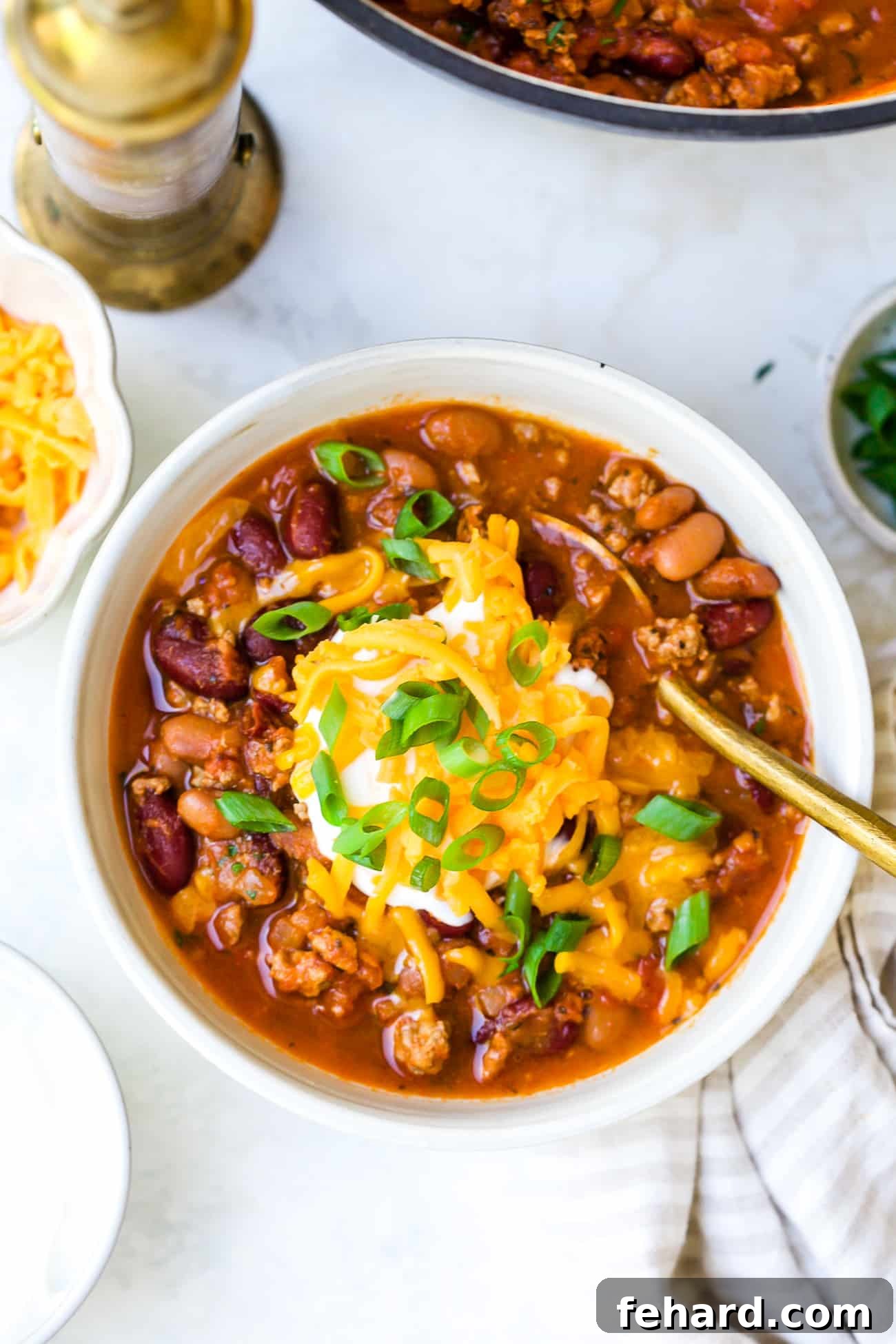 Close up of chili in a bowl with toppings.