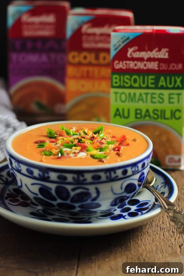 Close-up view of the rich, creamy texture of Campbell's Tomato Basil Bisque, perfectly complemented by savory bacon bits and fresh green onions.