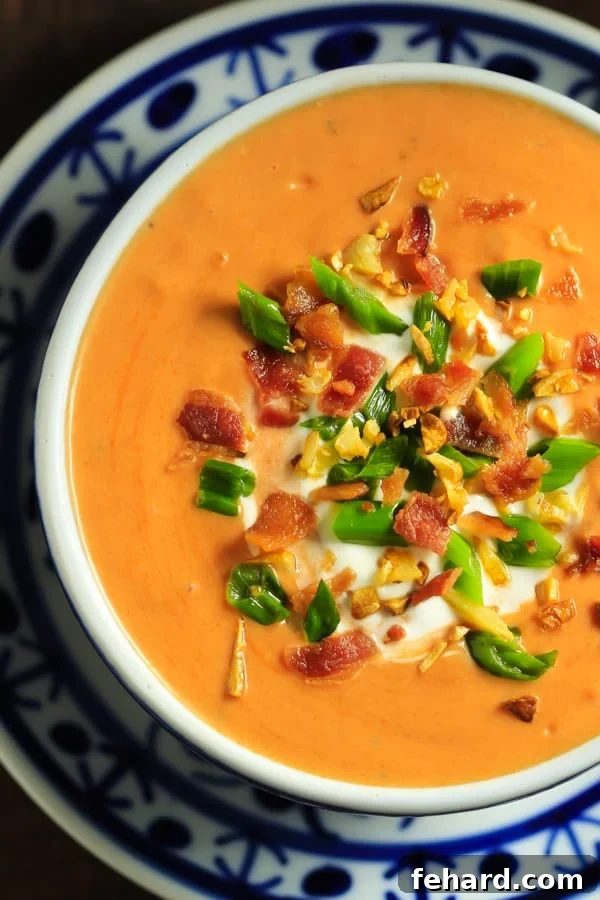 A vibrant bowl of Campbell's Everyday Gourmet Tomato Basil Bisque topped with crispy bacon, fresh garlic, and green onions, capturing the essence of an elevated quick meal.
