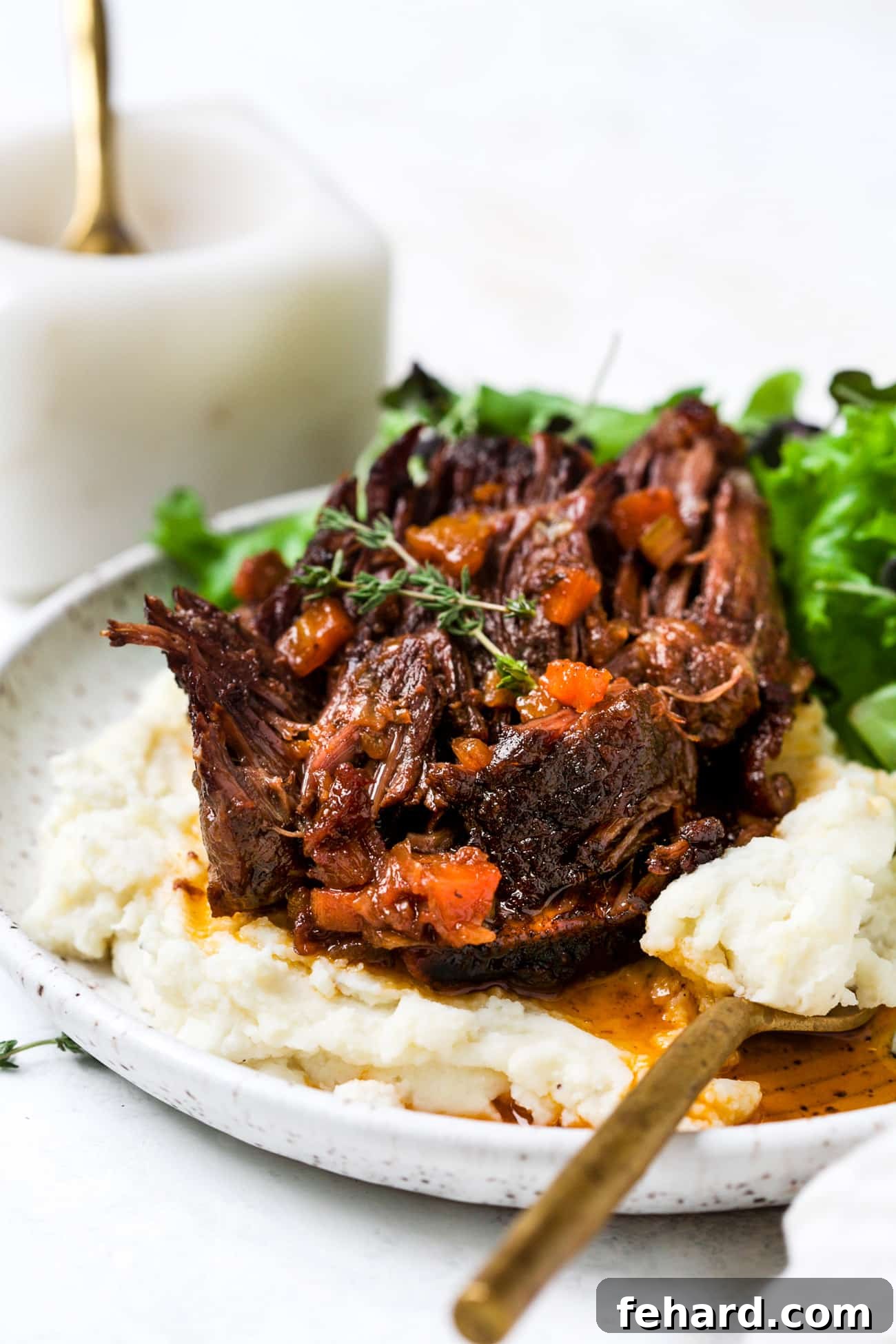 Red wine braised short ribs on a plate with mashed potatoes. 