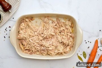 Shredded whole chicken in large casserole dish.