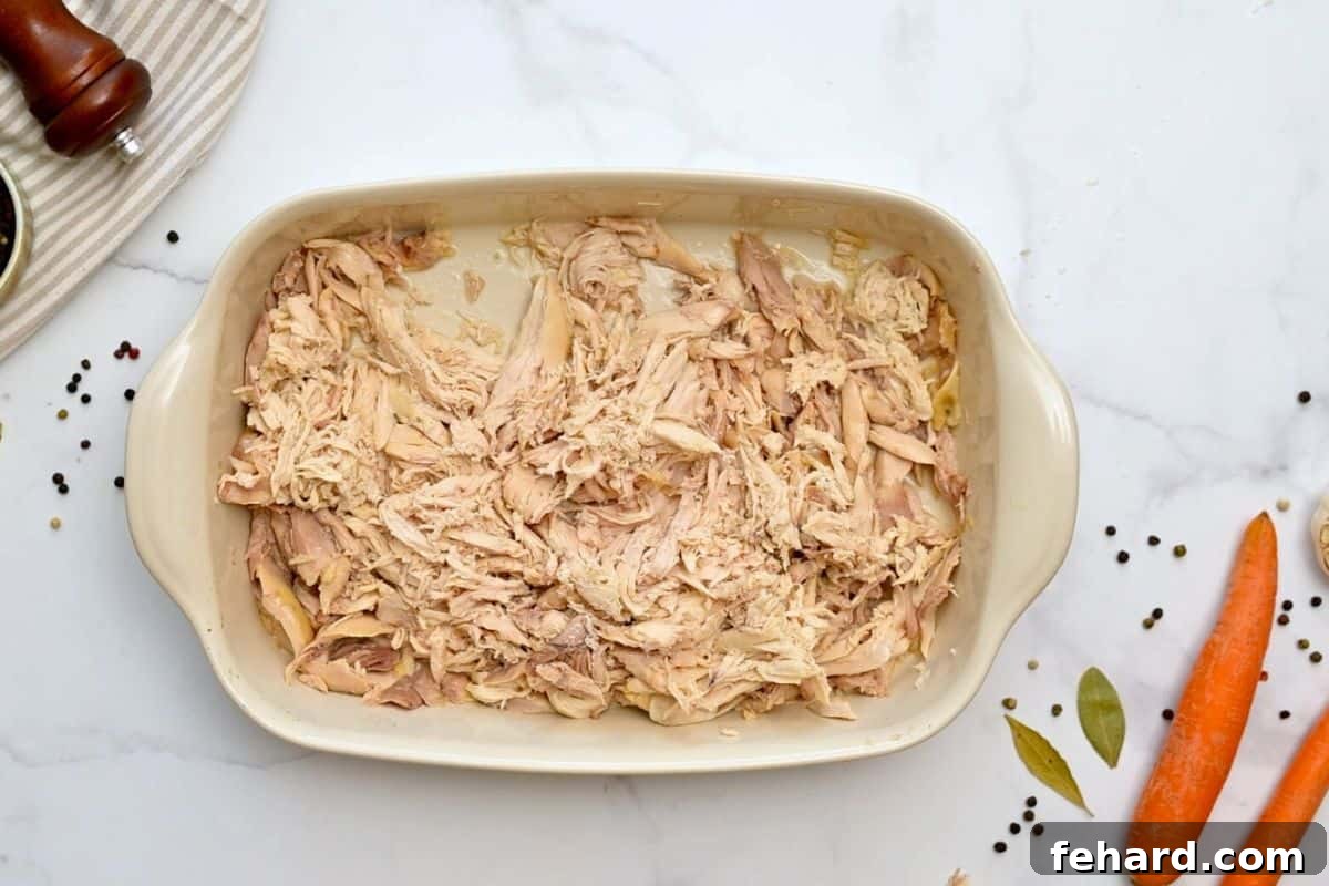 Shredded whole chicken in large casserole dish.