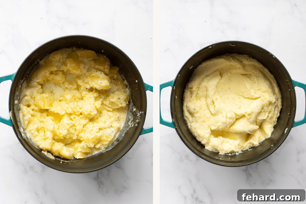 A hand mashing potatoes in a large pot, with roasted garlic paste, butter, salt, pepper, and heavy cream already added, creating a creamy texture.