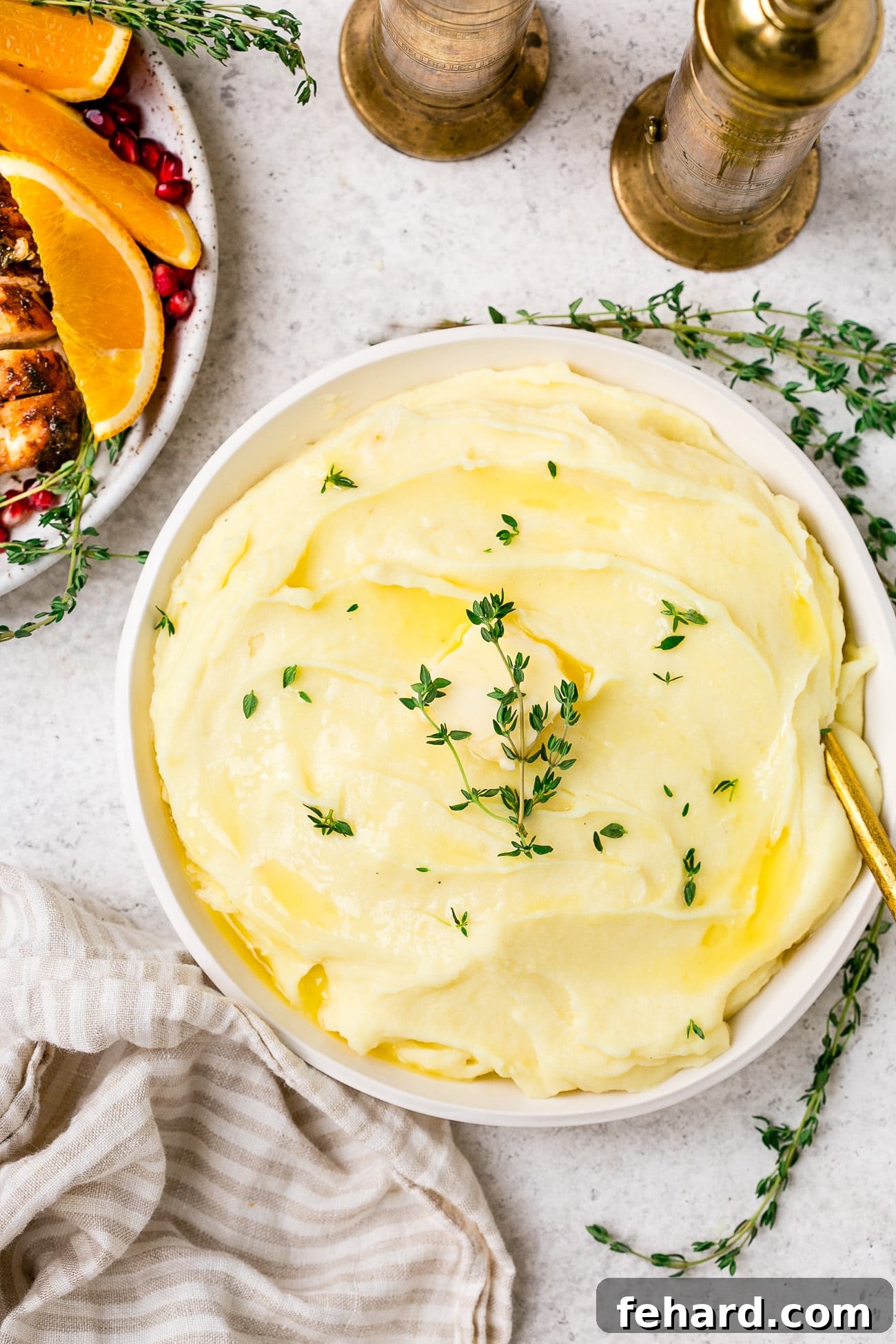 A generous serving of roasted garlic mashed potatoes in a rustic serving dish, beautifully garnished with fresh thyme, ready to be enjoyed.