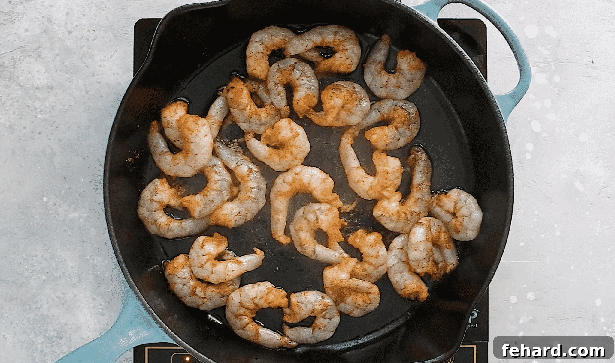 overhead view of cooked shrimp in a cast iron skillet.