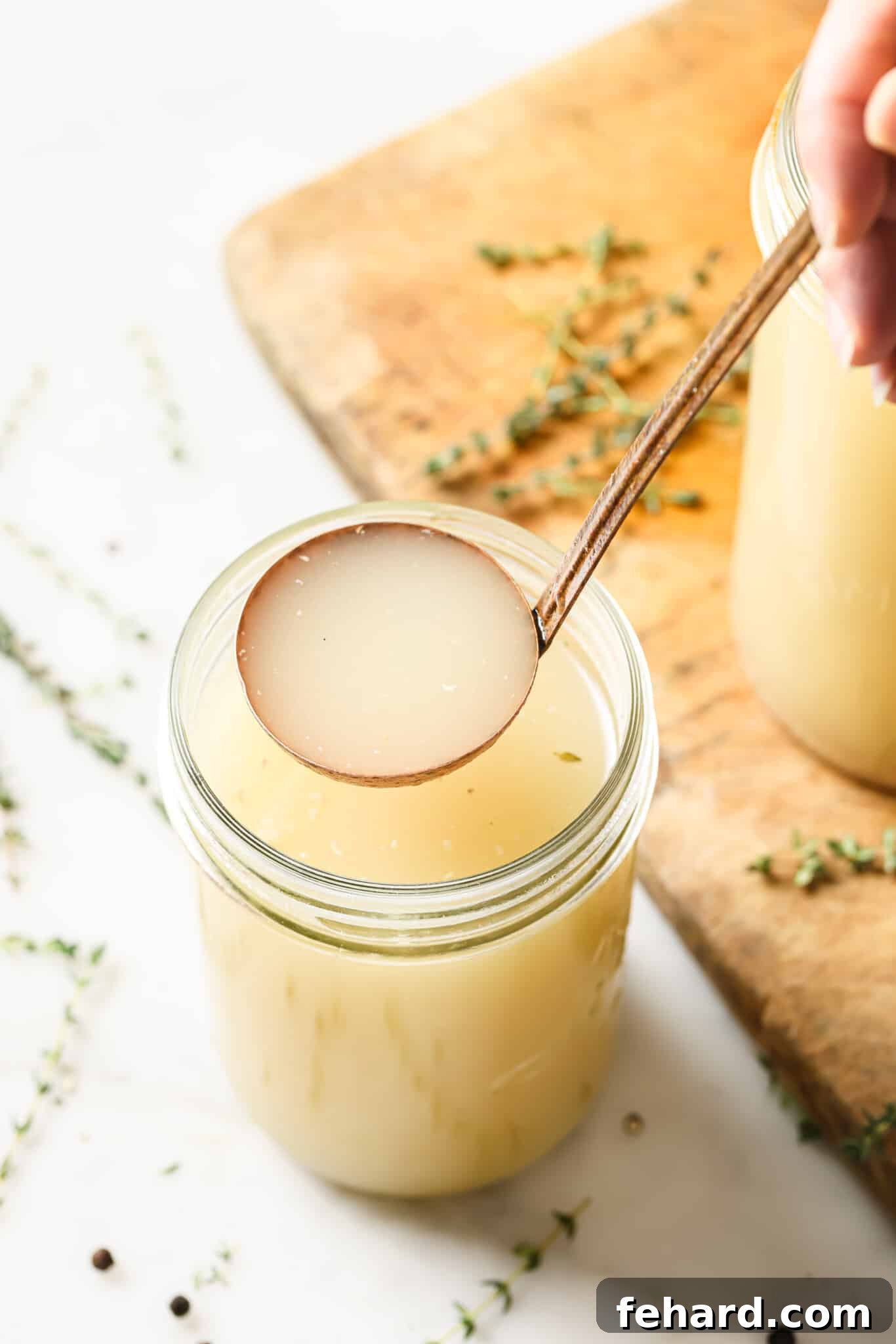A ladle serving turkey broth out of a mason jar. 